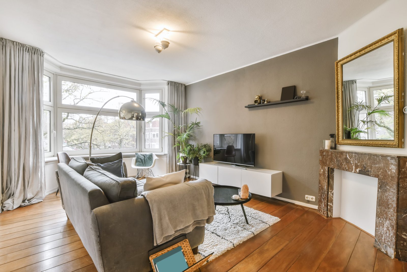 Delightful living room with a gray sofa and a lamp above it