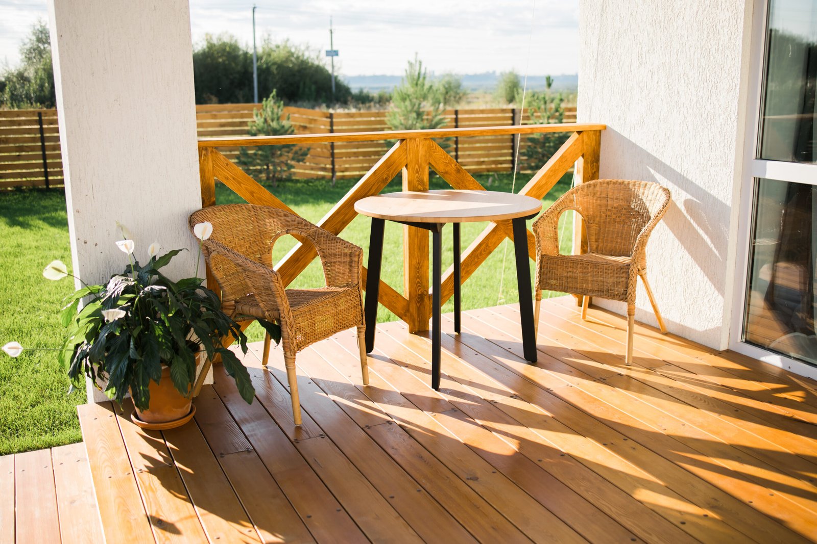 Cozy wooden terrace of country house or cottage with garden view - table and chair for relaxing evening. High quality photo